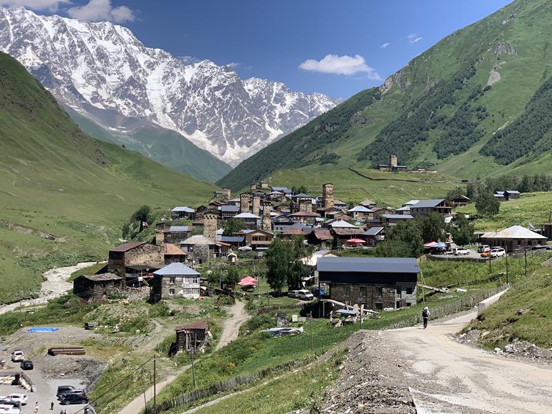 Das Bergdorf Uschguli mit seinen Wehrtürmen im georgischen Kaukasus, dahinter die vergletscherte Schchara